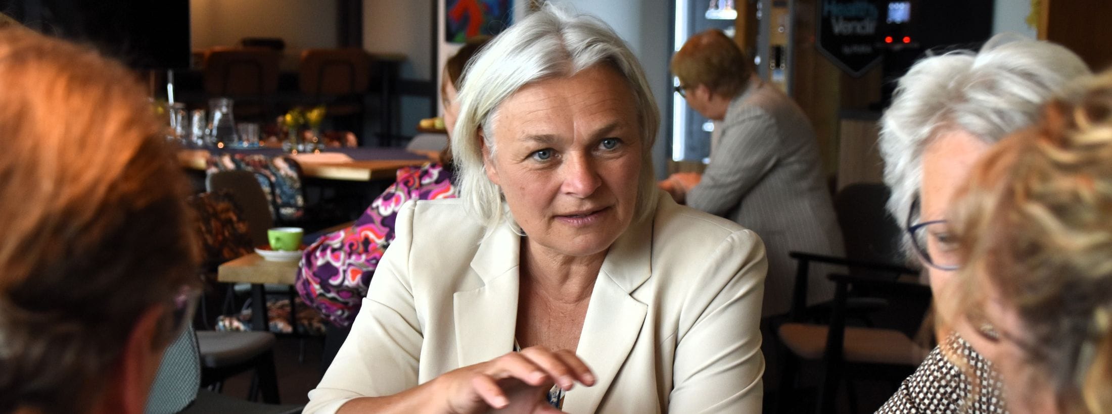 Raad van bestuur lid Wil van de Laar in gesprek met cliënten en medewerkers.