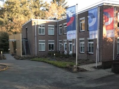 Buitenaanzicht van Hospice de Populier met drie wapperende vlaggen van Zorgboog.