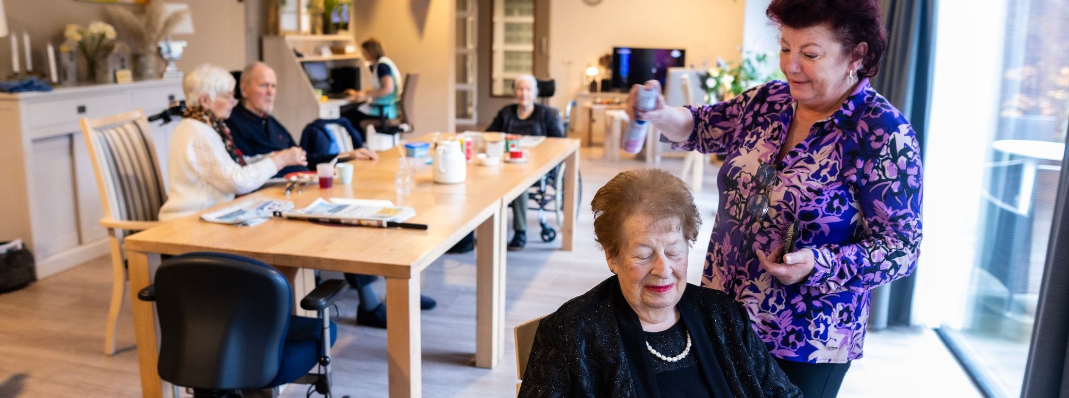 Bewoners, medewerkers en mantelzorgers in huiskamer kleinschalig wonen de Lindeboom in Stiphout